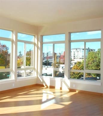 Empty room with large windows and hardwood floors