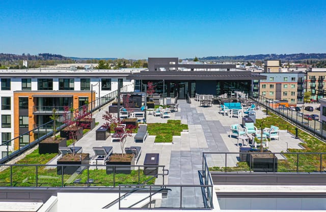 Rooftop terrace with lounge chairs, seating areas, and green spaces.