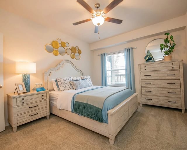 Bedroom with a queen-size bed, nightstand, dresser, and ceiling fan.