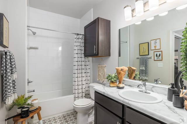 Bathroom with a shower/tub combo, vanity, and toilet.