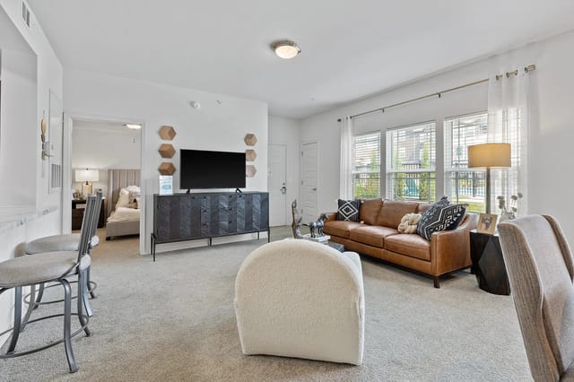 Cozy living room with a brown leather sofa and a television.