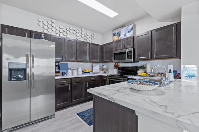 Modern kitchen with stainless steel appliances and marble countertop