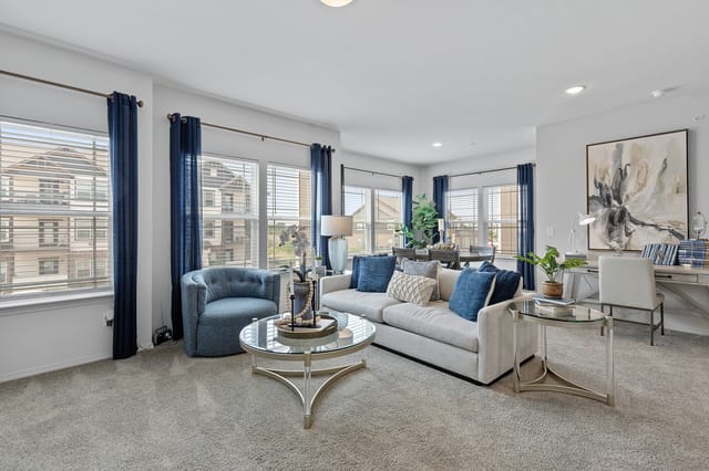 Spacious living room with a sofa, armchair, coffee table, and desk by the window.