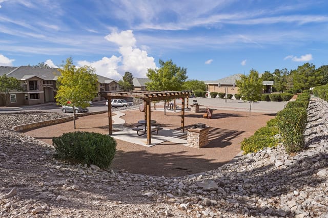 Outdoor picnic area with pergolas, picnic tables, and grills.