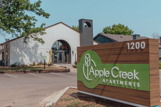 Exterior view of Apple Creek Apartments sign at the entrance.
