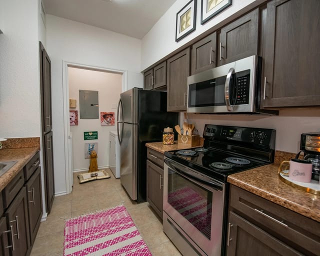 A kitchen with brown cabinets and a black stove top oven.