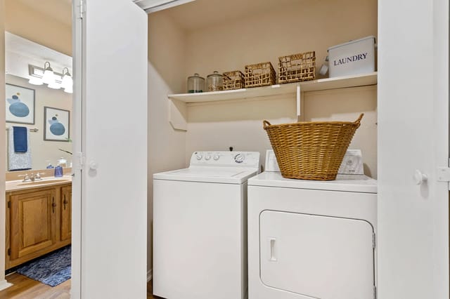 A laundry room with a washer and dryer and a basket on top of the dryer.