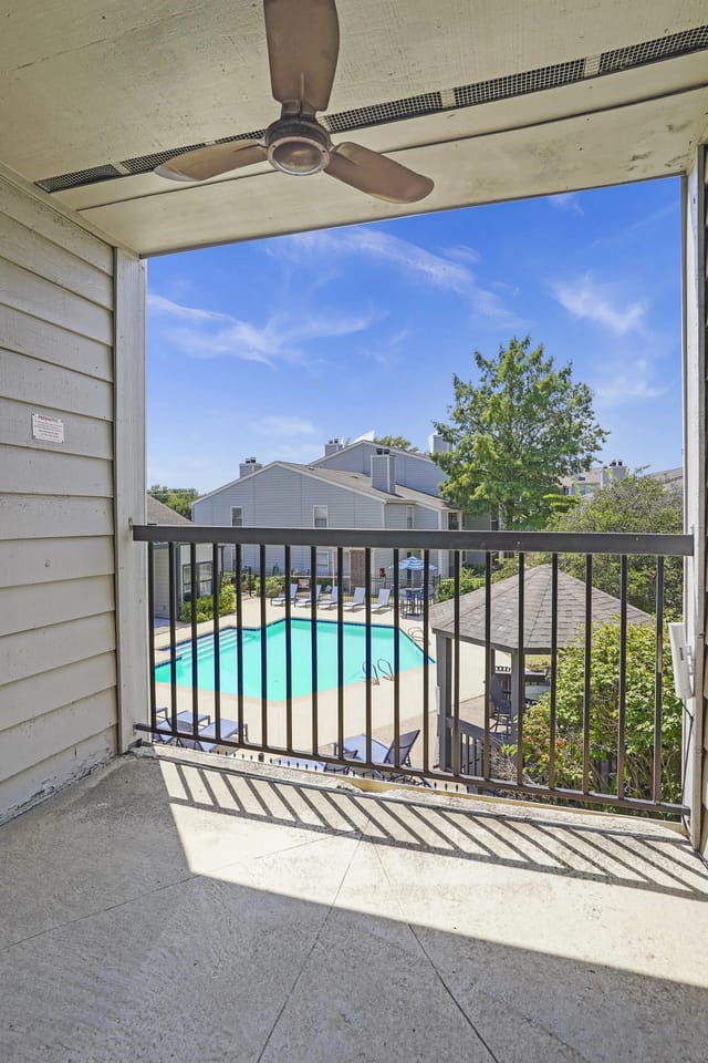 A balcony with a pool and a fan.