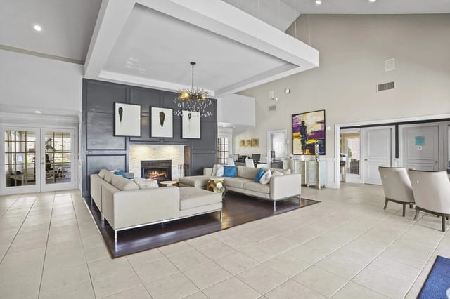 A modern living room with a fireplace and a chandelier.