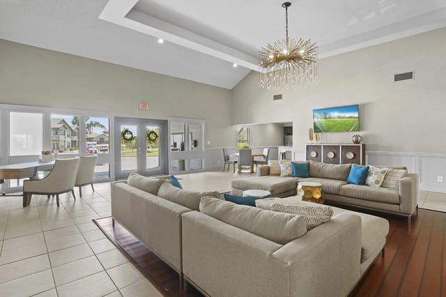 A living room with a large couch and a chandelier.