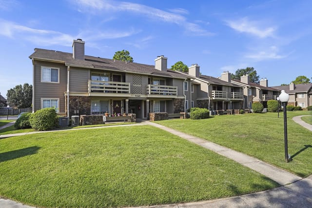Exterior view of a multi-building apartment complex with balconies and green lawn