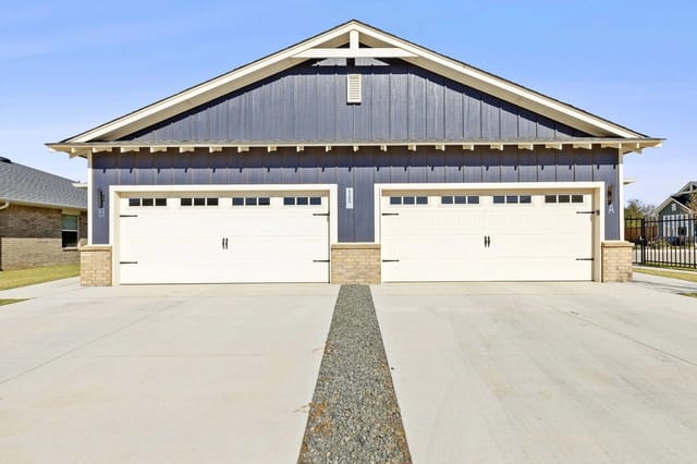 Two-car garage exterior with white doors and dark blue siding.