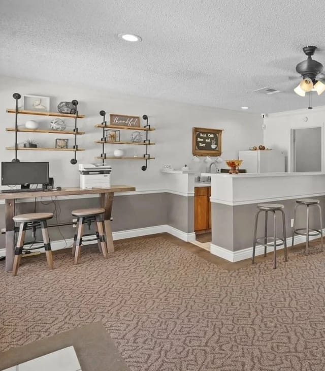 Community lounge area with a desk, printer, and coffee bar.