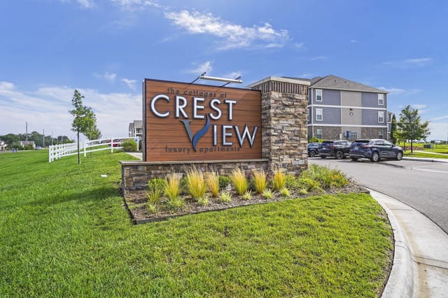 Crest View luxury apartments monument sign with landscaping and building in the background