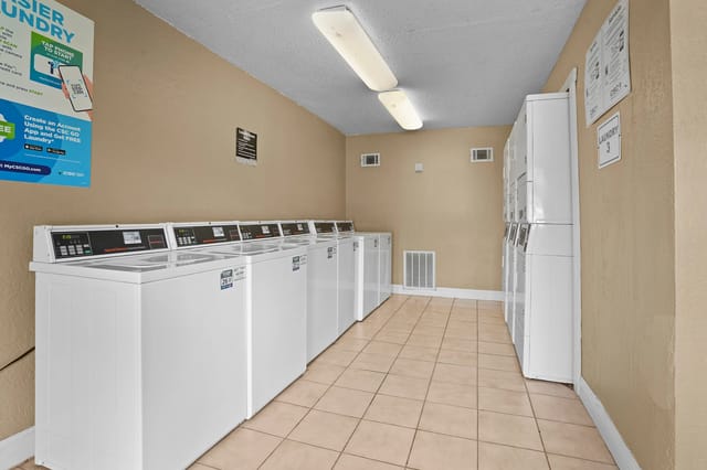Rows of washing and drying machines in a community laundry room.