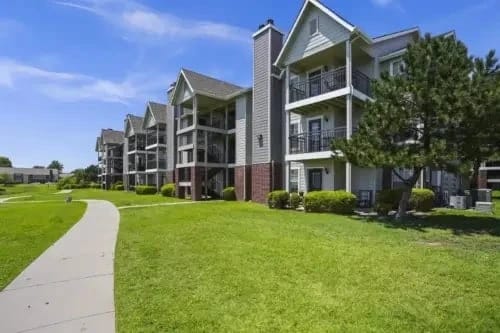 Exterior view of an apartment complex with grass and pathways