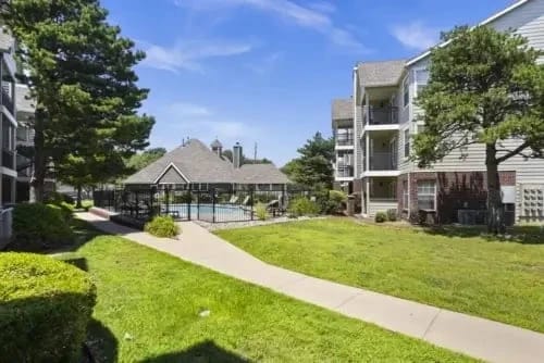 Exterior view of community with pool and landscaping.