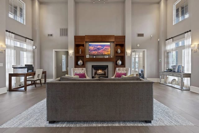 Spacious resident lounge with fireplace, seating area, and workstations.