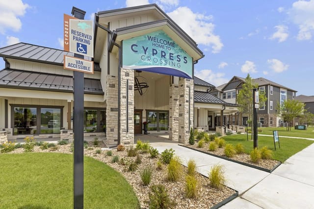 Exterior view of Cypress Crossing community entrance with a covered portico and landscaped walkways.