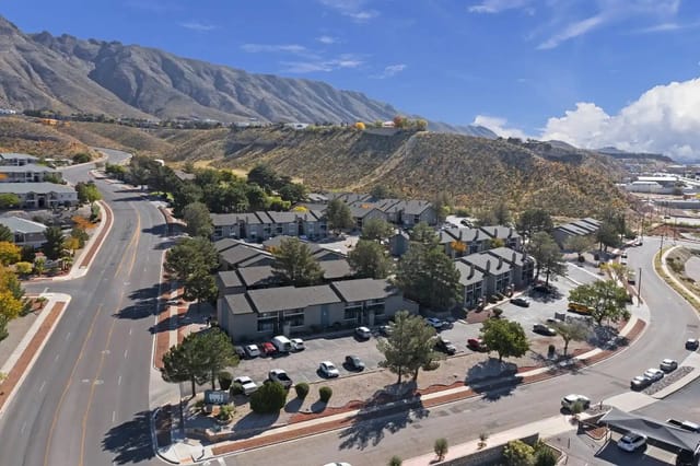 Aerial view of apartment complex with mountains in the background.