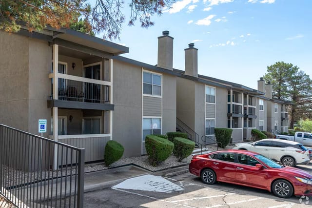 Exterior view of the apartment building with balconies and parking lot.