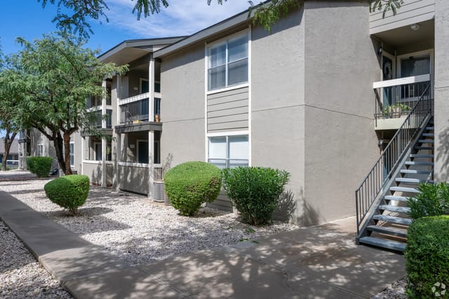 Exterior view of apartment building with stairs and balconies.