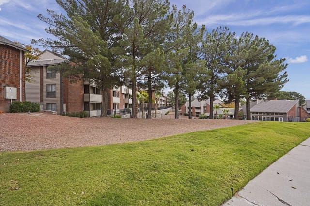 Exterior view of apartment buildings with trees and landscaping.