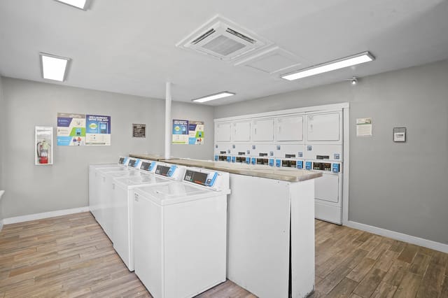 Laundry room with multiple washers and dryers.