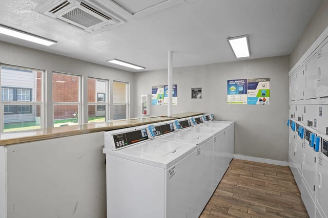 Laundry room with multiple washers and dryers.