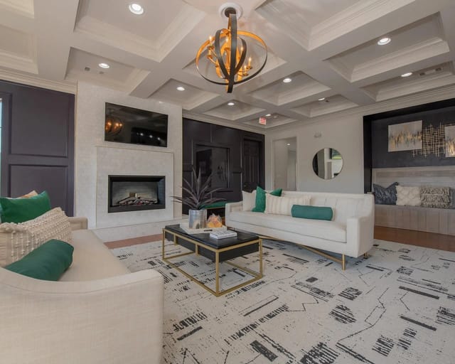 Modern apartment living room with white sofas, a fireplace, and a TV.