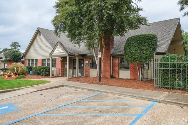 Exterior view of a leasing office at a multifamily property with handicap parking and landscaping.