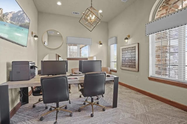 Interior of a communal computer center with desks, monitors, and office chairs.