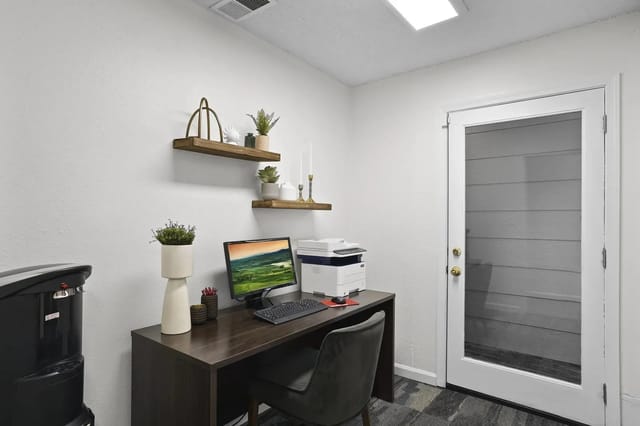 Office area with a desk, computer, printer, and water cooler.