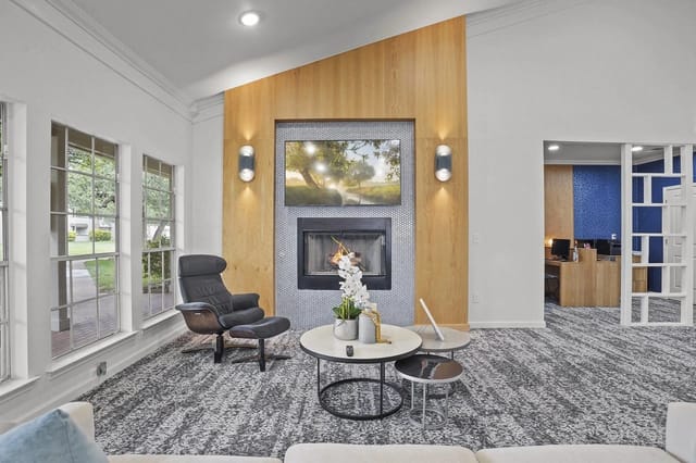 Modern lobby with a gas fireplace, comfortable seating, and large front windows.