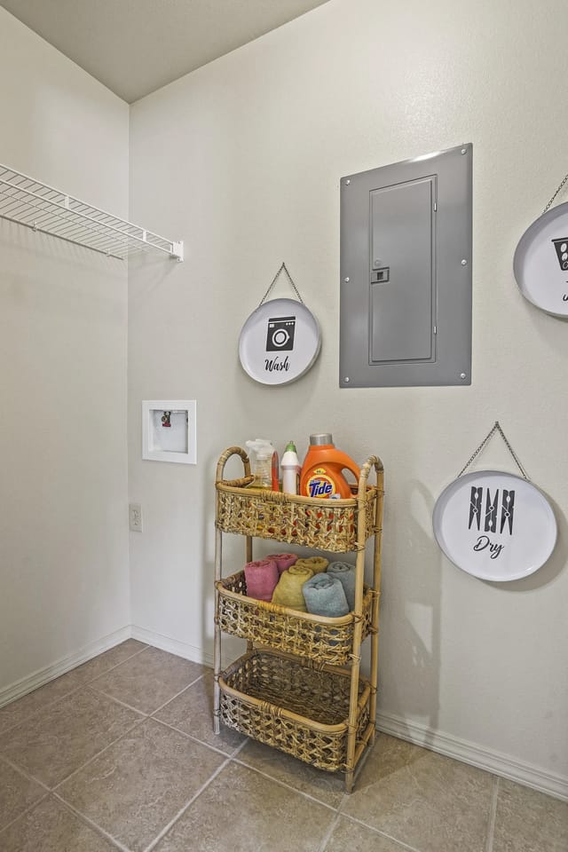 Laundry closet with wicker shelves, towels, detergent, and wall signs reading Wash and Dry.