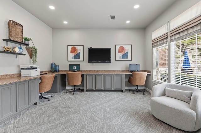 Business center with computers, printer, and seating.