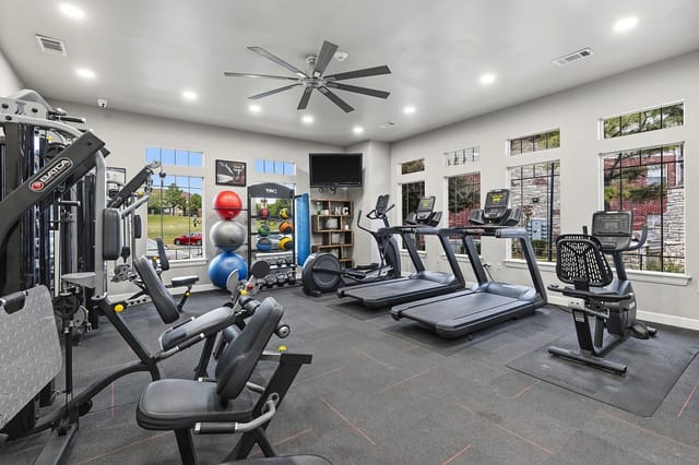 Fitness center with treadmills, ellipticals, weight machines, and free weights.
