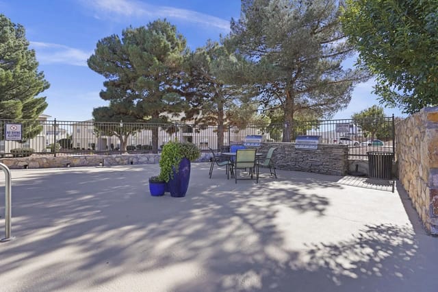 Outdoor grilling area with multiple grills, picnic tables, and seating.