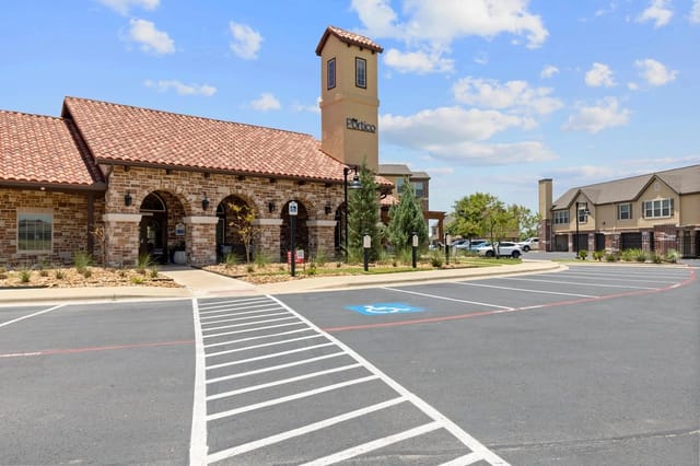 Portico apartment complex exterior with arched entryway and signage.
