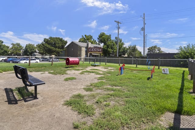 Dog park with agility equipment and seating.