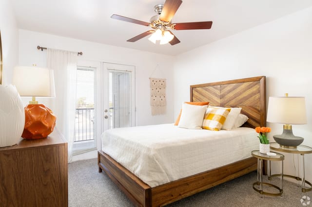 Bedroom with a queen-size bed, ceiling fan, and balcony access.