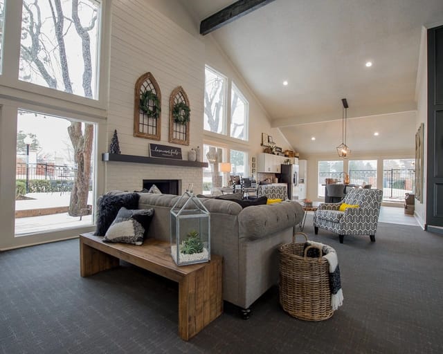 Bright community lounge with large windows, a fireplace, and comfortable seating.