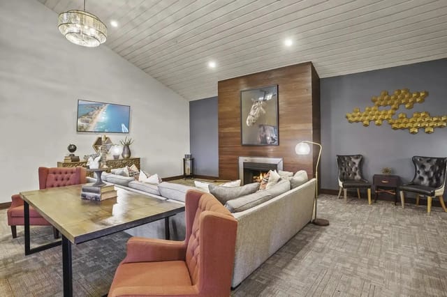 Interior lounge with sofa, chairs, and a fireplace in a modern communal space.