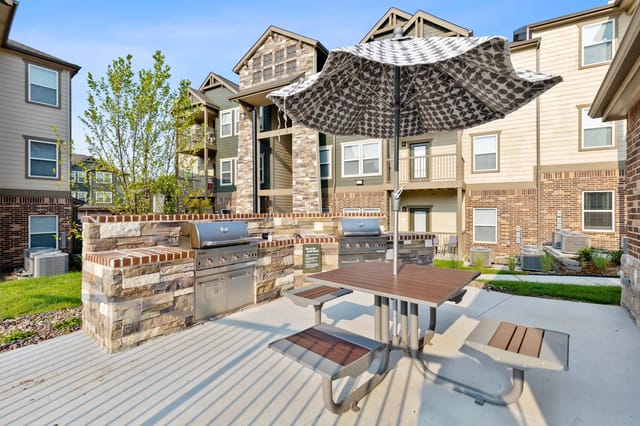 Outdoor grilling area with patio seating near the apartment buildings.