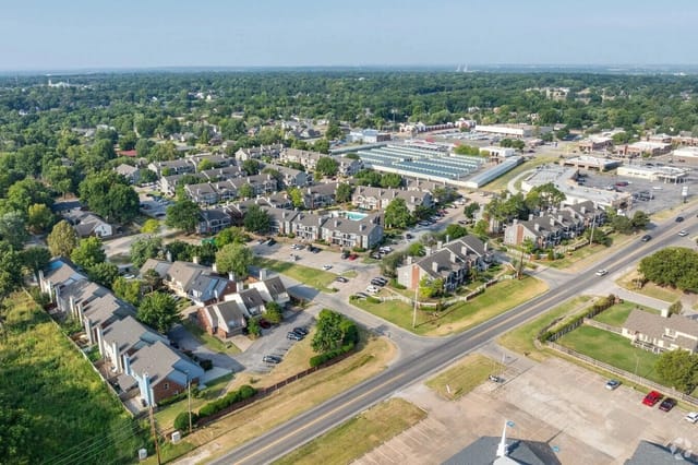 Aerial view of a sprawling apartment community with many buildings, parking lots, and green spaces.