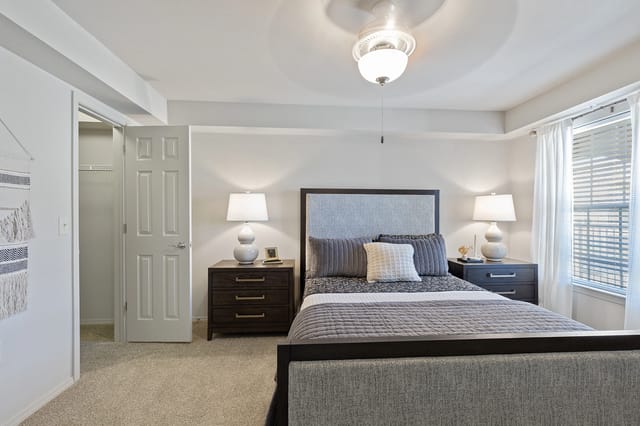 Bedroom with a king-size bed, nightstands, and a ceiling fan.