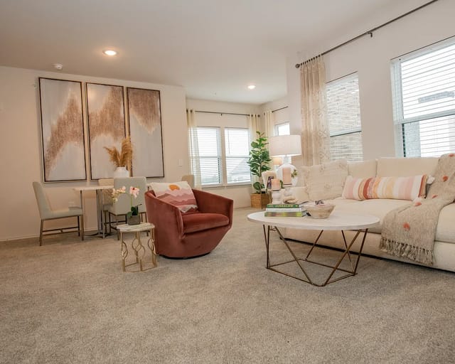 Bright living room in a modern apartment with a beige sofa and round coffee table.