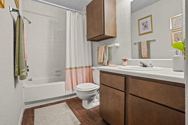 Updated bathroom with toilet, bathtub, shower, vanity, and sink.