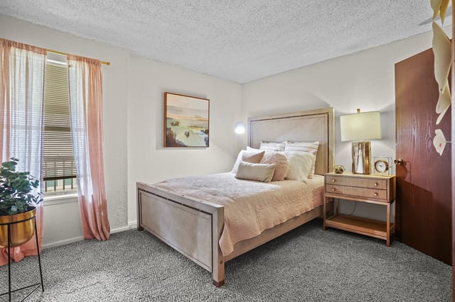 Cozy bedroom with a queen-size bed, plush bedding, and decorative pillows.