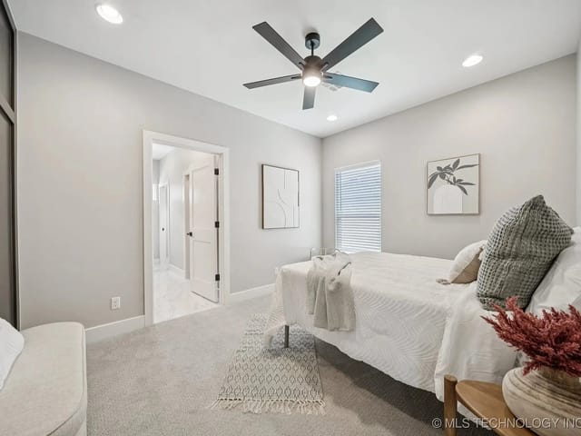 A cozy and modern bedroom featuring a bed, decorative pillows, and artwork on the walls.